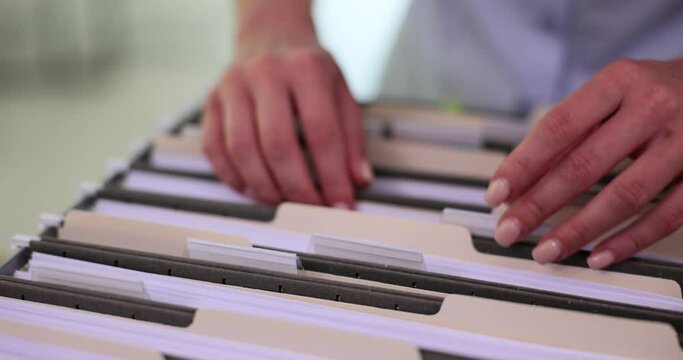 Tax inspector sorts documents in folder closeup. Organization of corporate document flow