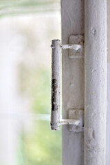 Dilapidated old window frame with metal vintage handle. Renovation in an old house