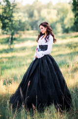 Fototapeta premium Portrait of magnificent Fashion gothic girl .Fantasy art work.Amazing brunette model in black white dress and hat posing.Fairytale about young princess 