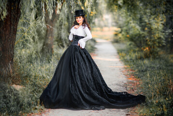 Portrait of magnificent Fashion gothic girl  .Fantasy art work.Amazing brunette model in black white dress and hat posing.Fairytale about young princess 
