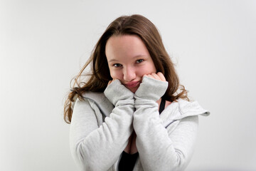 hug yourself young girl posing in front of camera teenager preparing stories and reels smile showing tenderness. in studio photo shoot shrug look to side at photographer alone in frame