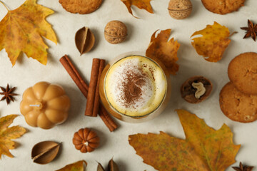 Pumpkin coffee, leaves and cinnamon on white background, top view