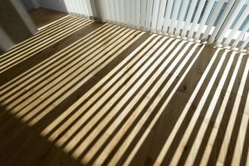 室内に差し込む日差しとブラインドの影