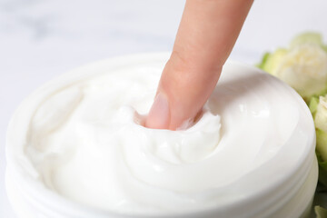 A jar of hand cream, close-up, on a light background.