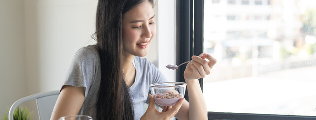 wellness food and lifestyle. Close up young girl eating yogurt and nuts as breakfast  at home.