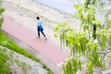 Cinder-track in a riverside park in spring, person running
