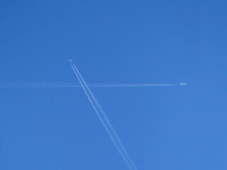 Two jet planes at high altitude with a passing vapor trail