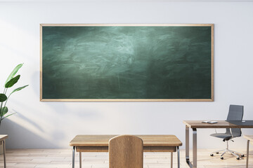 Modern classroom interior with empty mock up chalkboard, wooden furniture, daylight and equipment. Education, knowledge and workspace concept. 3D Rendering.