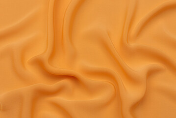 Orange silk satin curtain. Bright luxury background for design. Soft folds. Shiny golden draped...