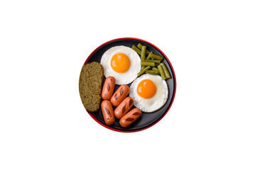 Tasty English breakfast of fried eggs, beans, asparagus, sausages with spices and herbs