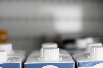 Easy to open screw caps on rows of milk cartoon boxes in supermarket.