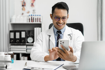 Fototapeta premium Medical Technology Concepts, Doctor is working on a smartphone and laptop computer in a modern office in the morning at the desk.