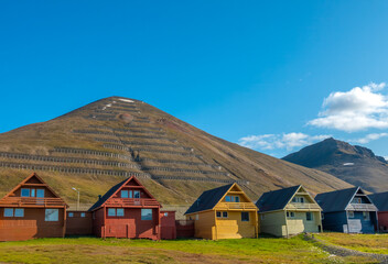 Fototapeta na wymiar Colorful old coal mining houses on the hills of Longyearbyen, the world's northernmost settlement, Spitsbergen, Svalbard, Norway