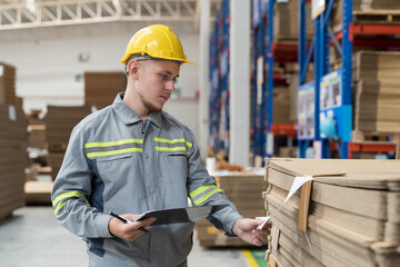Male warehouse worker working with check stock in warehouse. Male warehouse worker inspecting...
