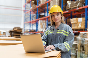 Female warehouse worker working with laptop computer for check stock in warehouse. Woman warehouse worker inspecting quality of barcodes on boxes on shelves pallet in storage warehouse