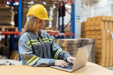Female warehouse worker working with laptop computer for check stock in warehouse. Woman warehouse...