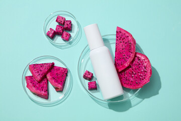 Petri dishes in different sizes containing red dragon fruit slices and a white bottle. Dragon fruit (Hylocereus) is packed with vitamins, minerals, and antioxidants