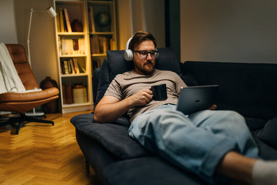 A mn is using digital tablet n the evening.