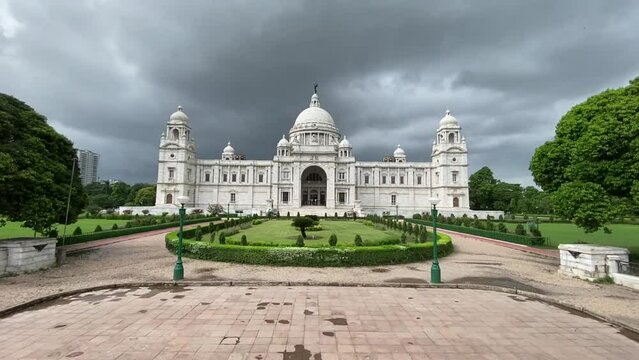 Front view of famous Victoria Memorial surrounded by beautiful garden in Kolkata, West Bengal, India on a cloudy day.