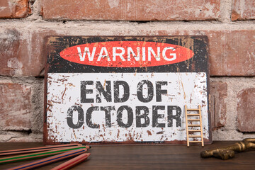 END OF OCTOBER. Warning sign on wooden office desk
