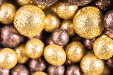 Colorful baubles decoration. Golden and brown glittering bubbles, macro. Balls textured with glittering paillettes. Event concept. Xmas background