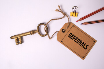 Referrals Concept. Cardboard price tag with text on a white background