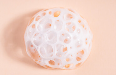 Foam texture on beige background, macro. Soap, shampoo, shower gel foam, face cleansing mousse or bubble mask sample. White cleanser foam bubbles on nude background.