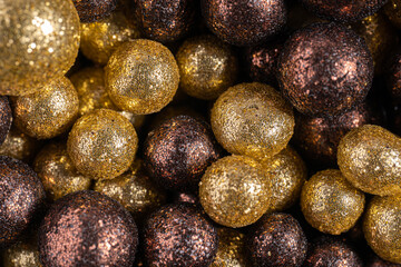 Colorful baubles decoration. Golden and brown glittering bubbles, macro. Balls textured with glittering paillettes. Event concept. Xmas background