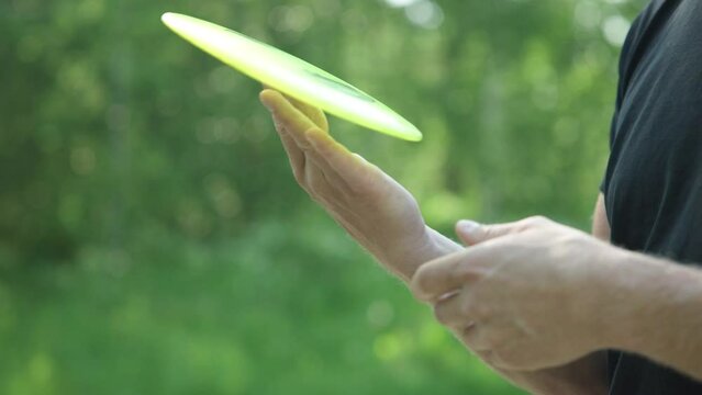 Close up of a person spinning a frisbee on his finger in slow motion