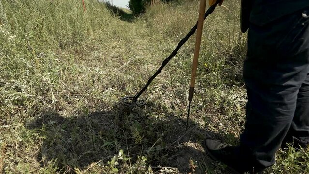 demining of territories that were occupied or where hostilities were conducted
a close-up of a sapper with a metal detector walks across the field scanning the surface for explosive objects