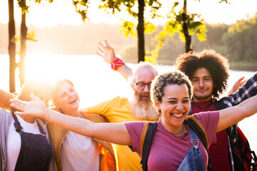 A group of multiracial, young friends gathers by the serene forest lakeside, their faces radiating sheer happiness during a summer vacation getaway. In a heartwarming moment, a vivacious young