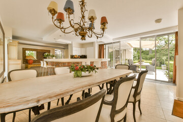 a dining room with a table, chairs and a chandel in the center of the room is an open patio