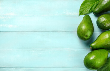Avocado on blue background. Avocado fruit with avocado leaves. Top view of avocado.