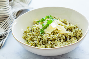 Green pesto risotto with parmesan, white background.