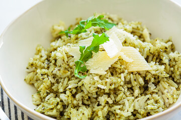 Green pesto risotto with parmesan, white background.