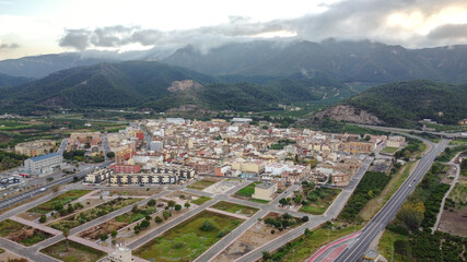 Aerial view of Favara, a spanish town in Valencia province surrounded by mountain range called La Murta y la Casella covered by clouds - obrazy, fototapety, plakaty