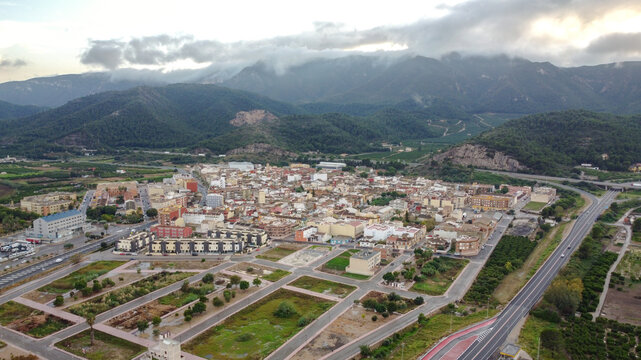 Aerial view of Favara, a spanish town in Valencia province surrounded by mountain range called La Murta y la Casella covered by clouds