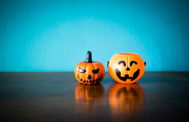 Funny Halloween pumpkin on wooden table with space on blurred blue background, Halloween decoration item