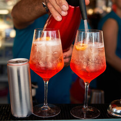 Spritz traditional cocktail with alcohol being prepared in a beach bar. Italian drink. Lifestyle concept