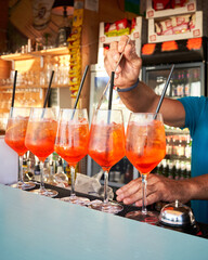 Spritz traditional cocktail with alcohol being prepared in a beach bar. Italian drink. Lifestyle concept