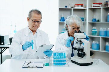 Asian senior Scientist team meeting and writing analysis results in the laboratory study and...