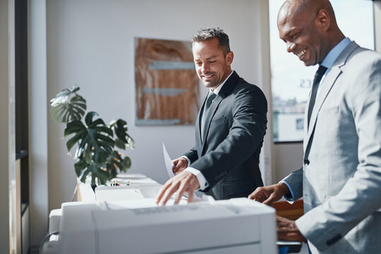 Businssmen working in office by a printing machine