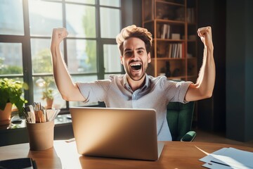 businessman raising both hands celebrating his success in front of laptop