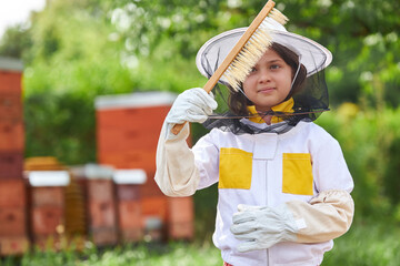 Girl analyzing hive brush at apiary garden
