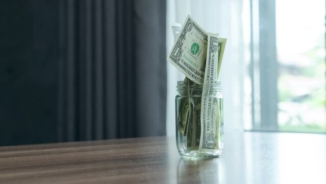 Money Increases in empty jar, stop motion, 4k footage