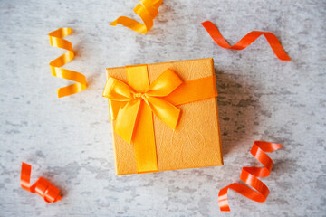 orange color gift box with ribbon on whie wooden background top view. Present party concept