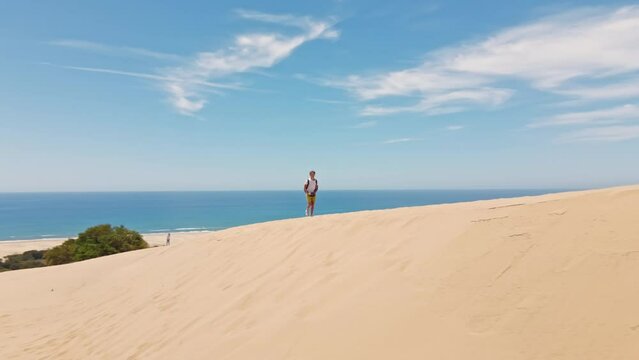 aerial footage man traveler drone pilot with RC walking sandy dunes on beautiful Patara Beach on Mediterranean sea coastline. wanderlust, travel and filming content for social media. amazing Turkie