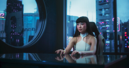 Stylish Japanese Young Woman Interacting with Augmented Reality Platform in a Technologically Advanced Room. She is Using Glass Interactive Desk with Futuristic Cyberpunk City in the Background.