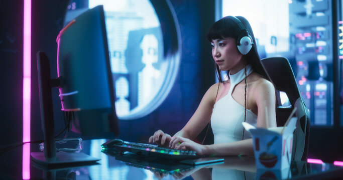 Beautiful Japanese Streamer Hosting a Live Internet Show, Having an Interview on a Video Call. Young Podcaster Using Computer, Chatting with Friends Online in a Futuristic Cyberpunk Studio