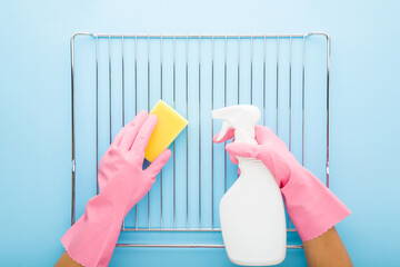 Woman hands in rubber protective gloves holding white detergent bottle, sponge and washing steel...